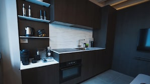 A modern kitchen with dark wood cabinets, a marble backsplash, a built-in oven, and a countertop with various appliances. - Modern apartment in downtown Parma, WiFi and comfort (Parma)
