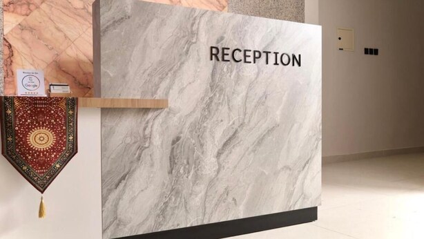 A reception desk with a marble top and the word 'RECEPTION' on it. - Moodar (Madinah)