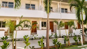 A multi-story hotel with a pool area, palm trees, and a sign reading 'MOALBOWL.'