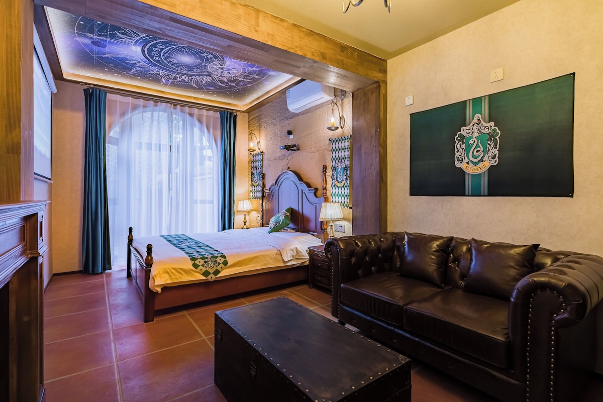 Ein Schlafzimmer mit einem Bett, einem Ledersofa, einem Nachttisch und einer Wandlampe.