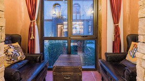 A room with two leather armchairs, a wooden chest, and a large window with curtains. - Beijing Magic Villa (Tongzhou)