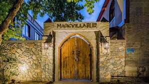 A stone archway with a wooden door and a sign above it. - Beijing Magic Villa (Tongzhou)