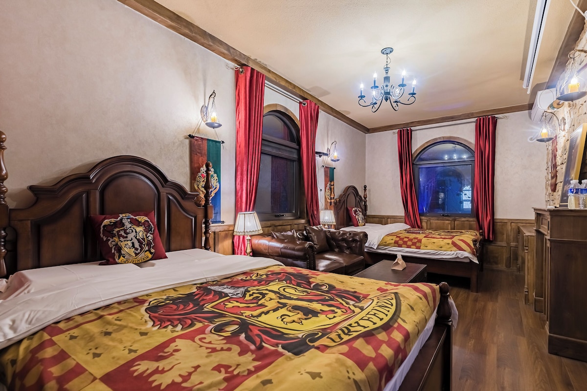 Ein Zimmer mit zwei Betten, einem Chandelier, roten Vorhängen und einem hölzernen Kopfteil.