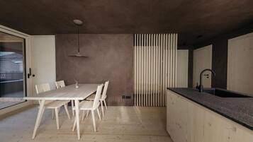 Una cucina moderna con un tavolo e sedie in legno, un piano di lavoro nero e una finestra con vista.