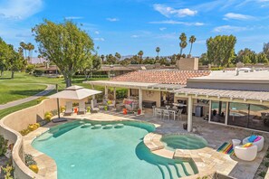 A pool area with a pergola, outdoor seating, and a view of a golf course. - Courtside Escape - Country Club Living (Rancho Mirage)