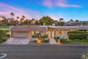Une maison moderne à deux étages, dotée d’un garage, d’une allée et d’une pelouse bien entretenue.