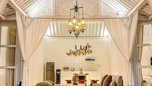 A spacious living area with a high ceiling, a chandelier, and a seating arrangement. - Hafrana Villa by AGATA - 700sqm 2BR Villa with Private Pool & Jacuzzi (Selat)