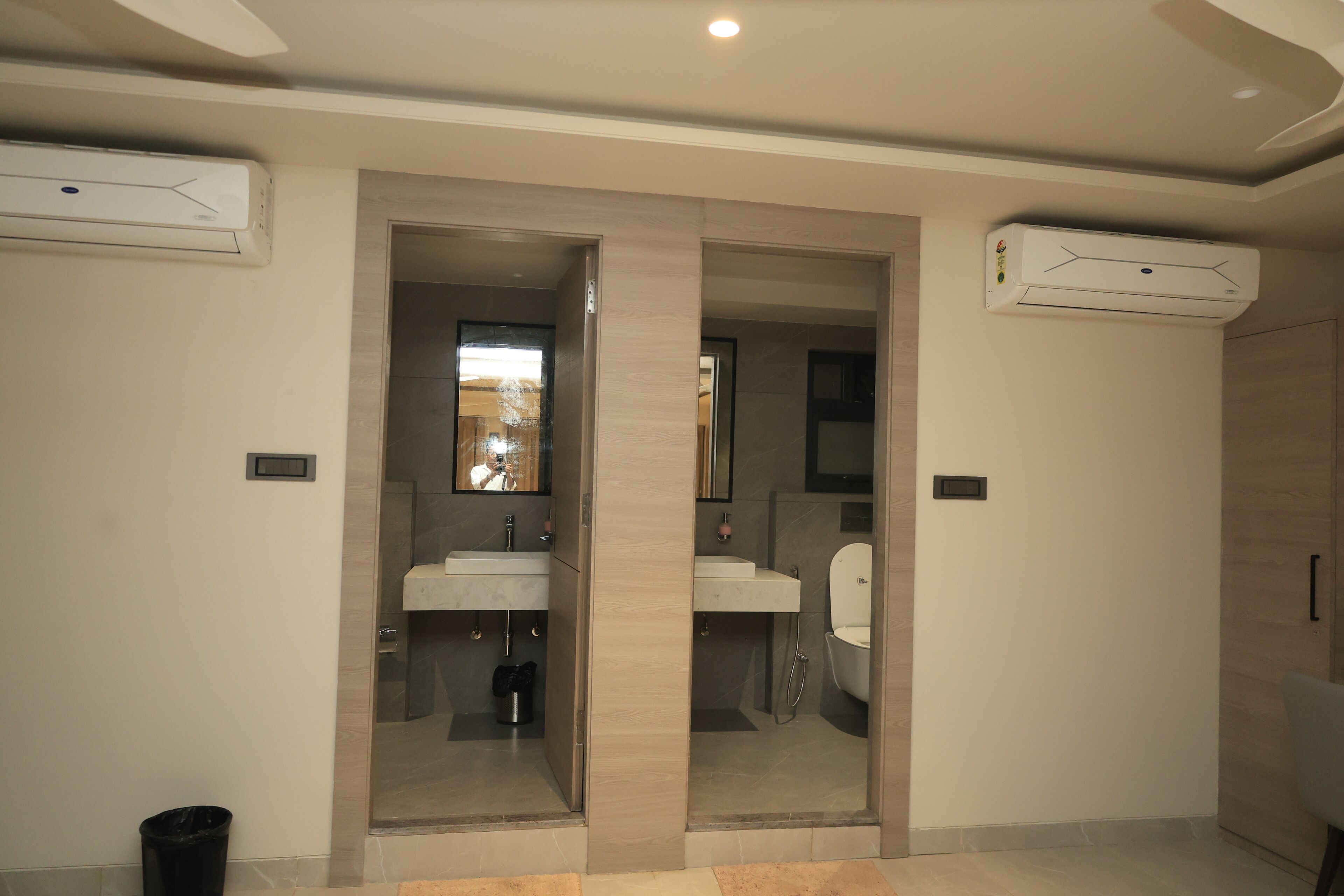 Een moderne badkamer met twee wastafels, een spiegel en een douche.
