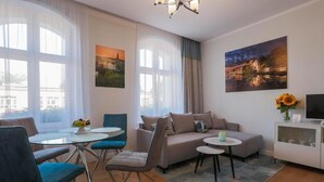 Un salon moderne comprenant un canapé, des fauteuils, une petite table et un meuble pour la télévision.