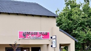 Un bâtiment sur lequel on peut voir une enseigne indiquant « Image Plus, centre d’esthétique », ainsi qu’un distributeur automatique de billets.