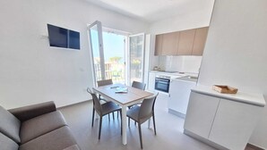 Un apartamento moderno con comedor, kitchenette y sofá.