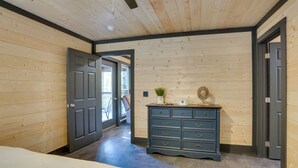 A bedroom with a bed, a dresser, and a door leading to another room. - Walk to Kentucky Lake! Pet-Friendly Murray Duplex (Murray)