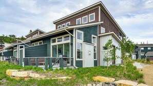 Een moderne, tweelaags woning met een balkon, een omheind buitengebied en een pad van natuursteen.
