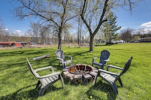 A grassy outdoor area with a fire pit and Adirondack chairs. - Dog-Friendly Home w/ Dock & Views on Waneta Lake! (Wayne)