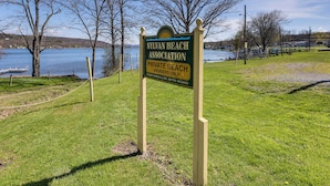 A sign for Silvan Beach Association Private Beach, with a grassy area and trees in the background. - Dog-Friendly Waneta Lake Home w/ Lake Access! (Wayne)