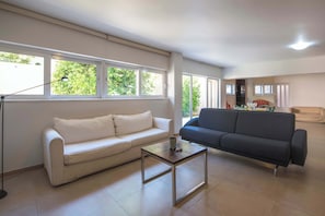 A living room with a white sofa, a dark sofa, and a glass coffee table. - Elegant Urban Retreat in Psychiko 2 (Psichiko)
