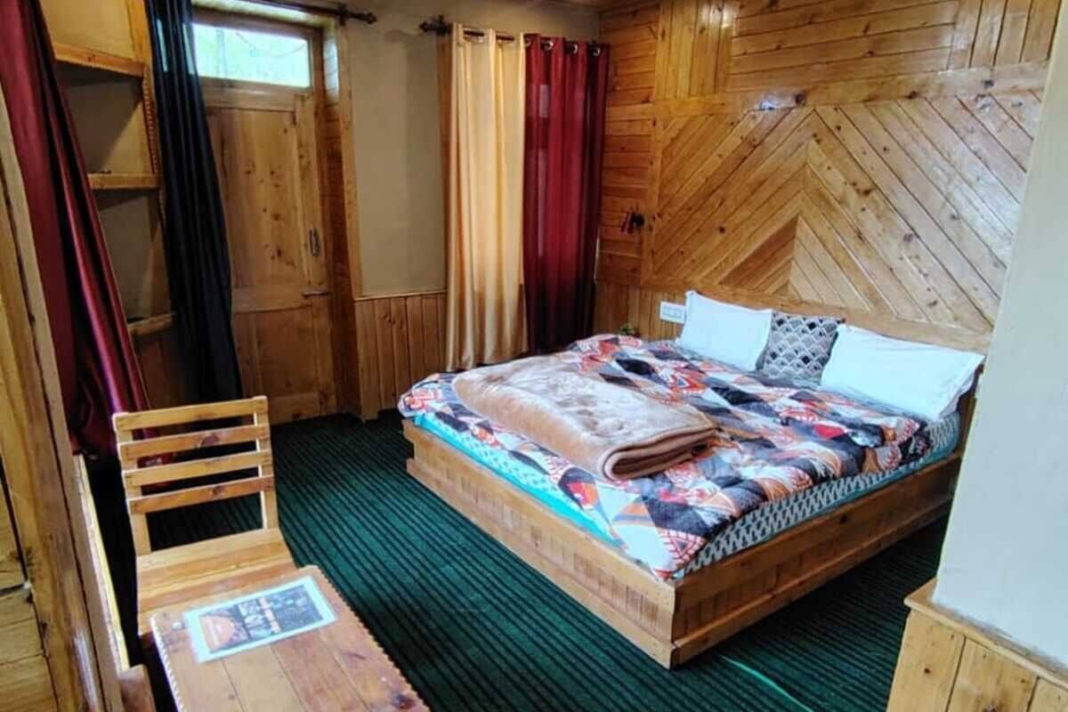 Camera da letto in un rifugio di legno, con un letto, un tavolo e una sedia.