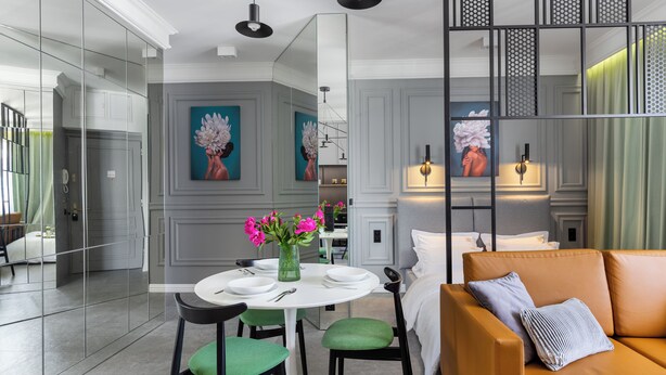 A modern interior with a dining area, a sofa, and artwork on the walls. - Skawinska Suites by Fragola Apartments (Kraków)