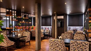 Ein Restaurant mit Holzböden, gemusterten Stühlen und Tischen.