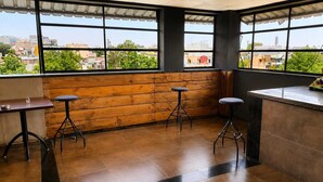 Ein Restaurant mit Blick auf die Stadt, Holzwänden und modernen Hocker.