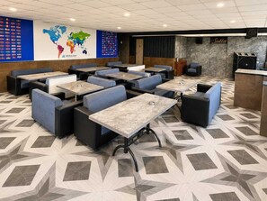 A hotel lobby with seating areas, a world map, and a reception desk. - The Grand Courtyard Maan (Indore)