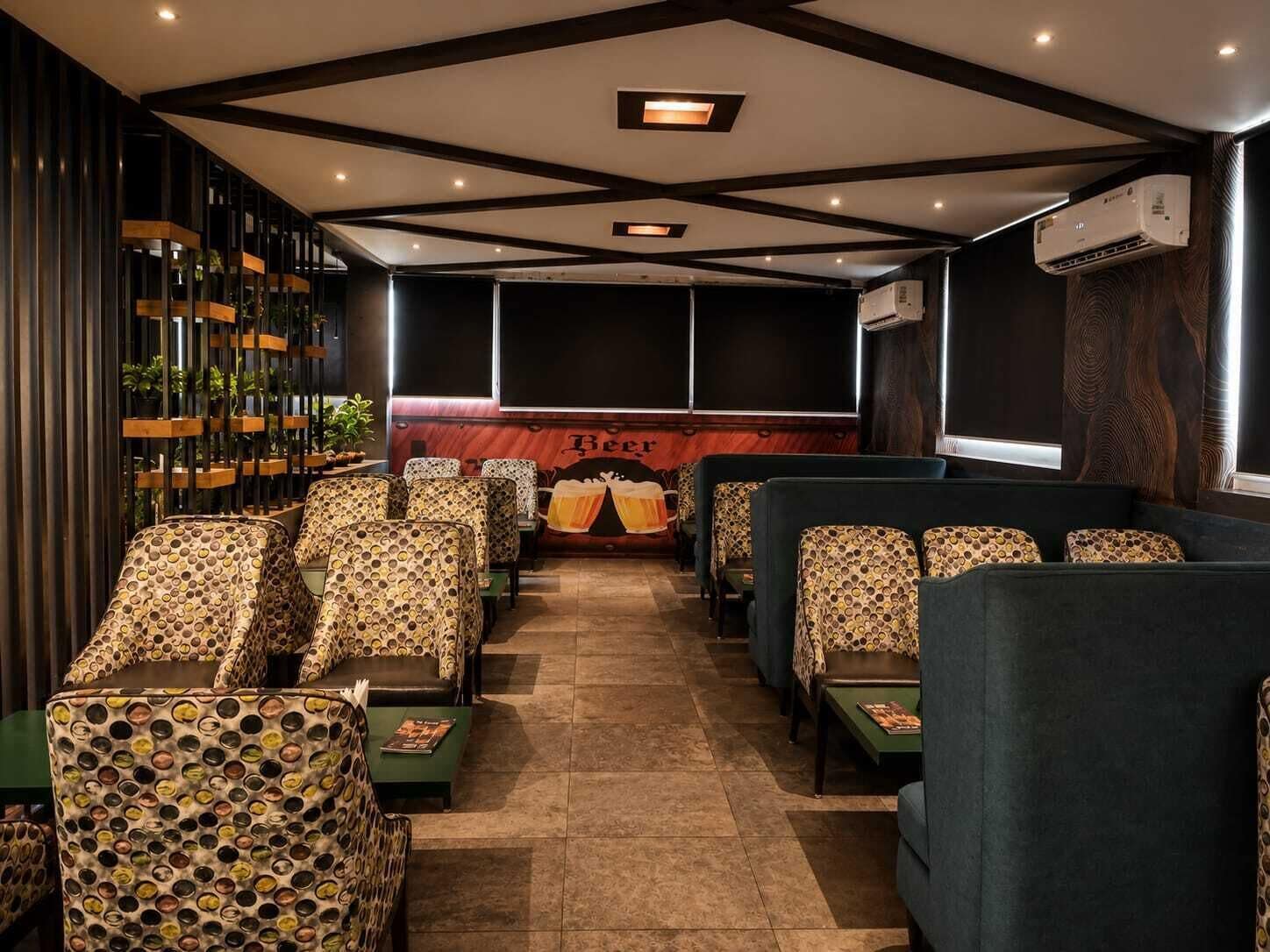 A cinema with patterned seating, a large screen, and an air conditioning unit.