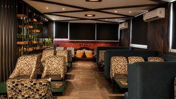 A cinema with patterned seating, a large screen, and an air conditioning unit.