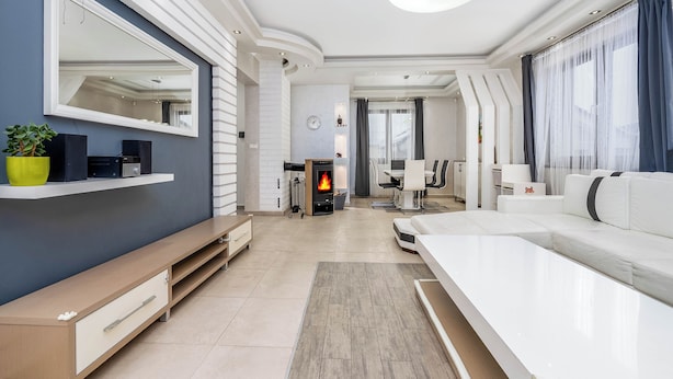 A modern living room with a fireplace, a large mirror, and a sofa. - Spacious 6-bedroom villa in gorgeous Králův Dvůr with fitness room and terrace (Králův Dvůr)