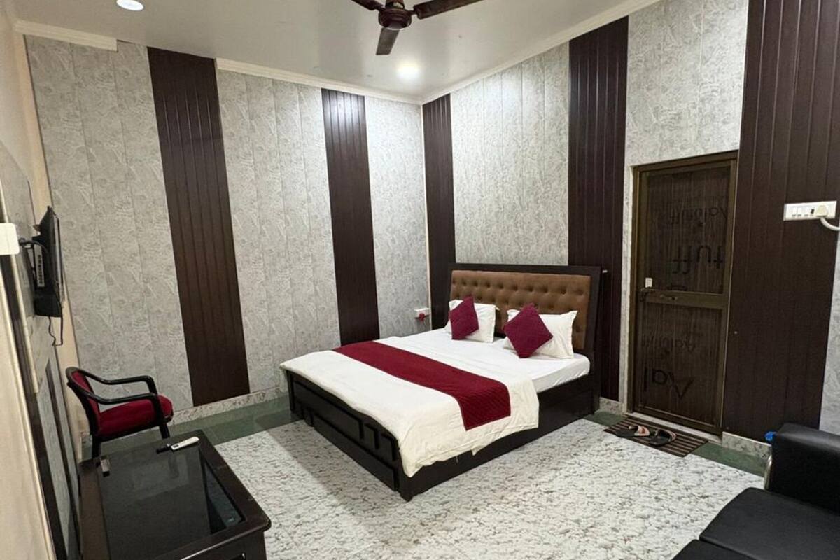 A bedroom with a bed, a ceiling fan, a nightstand, a chair, and a door.
