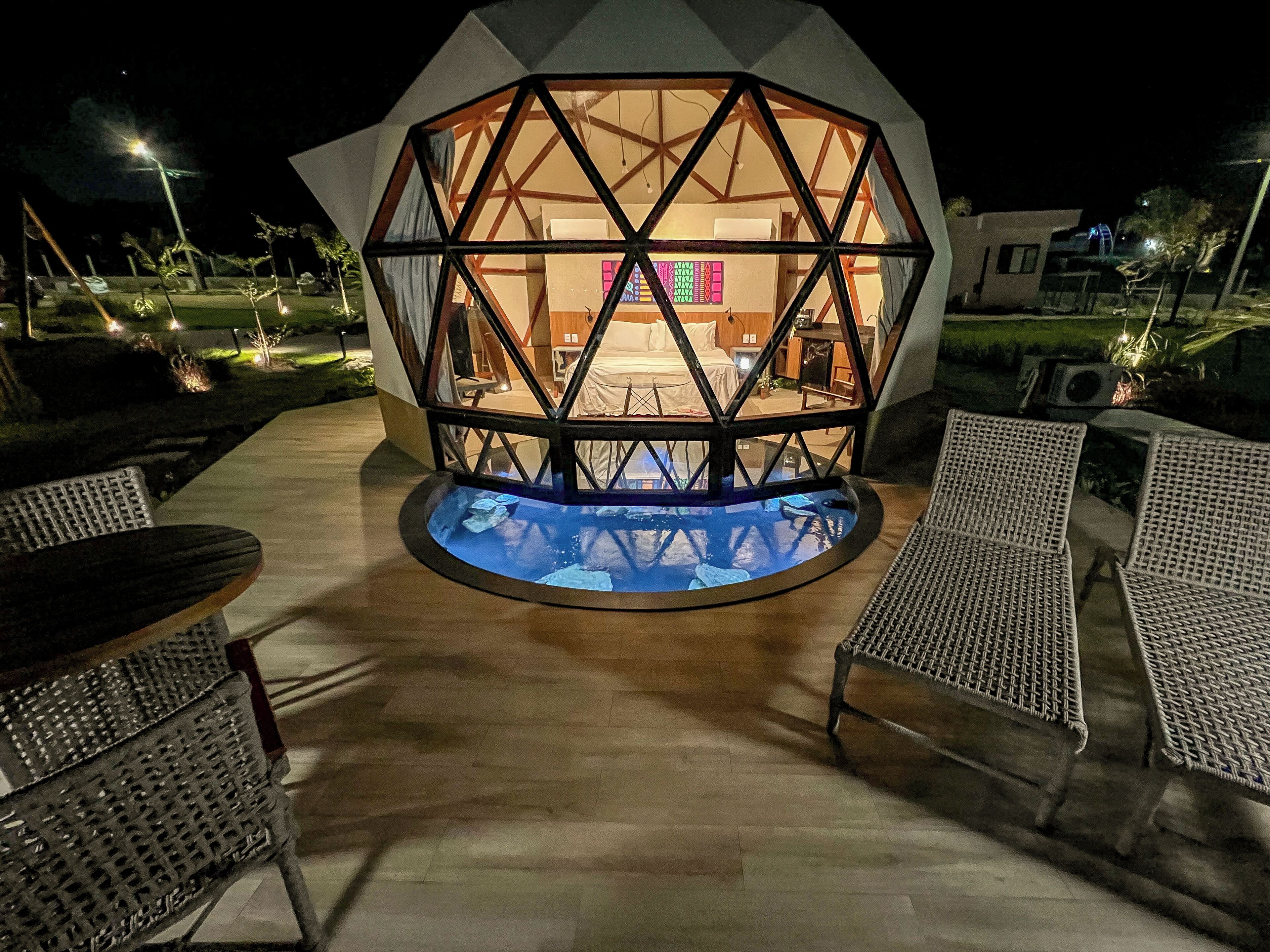 A hexagonal structure with a pool in the center, surrounded by outdoor seating.