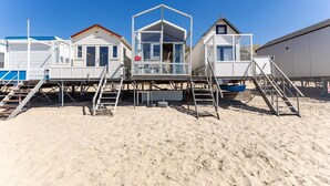 Eine Reihe von Strandbungalows mit Außentreppen zum Strand.