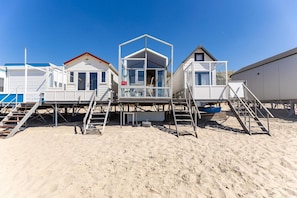 A row of beachside mobile homes with external staircases leading to the beach. - Beachhouse with sea views in Dishoek (Koudekerke)