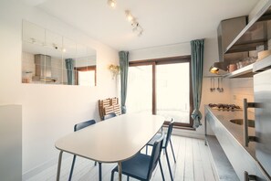 A modern kitchen with a dining area, large windows, and a view of the outdoors. - 3-bedroom apartment in National Residence (Belgium)