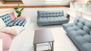 A loft-style living room with a high ceiling, a skylight, a blue sofa, a wooden coffee table, and a white shelving unit. - 3-bedroom apartment in National Residence (Belgium)