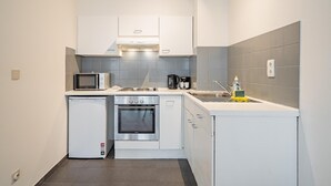 Uma cozinha compacta com micro-ondas, fogão, forno e pia.