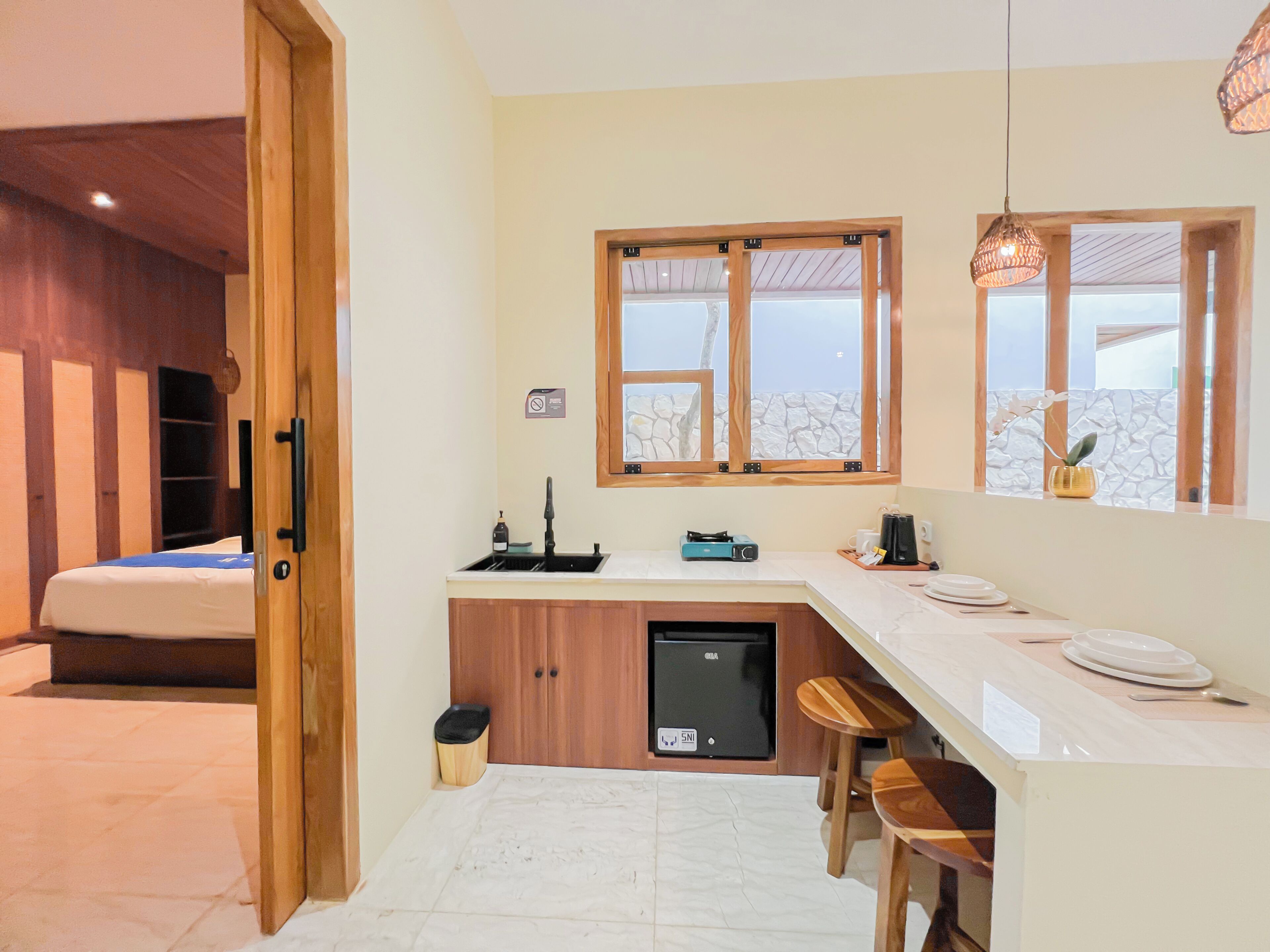 A compact kitchen with a built-in dishwasher, a small sink, and a window with a view.