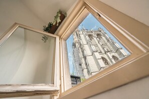 A window with a view of a historic building with intricate architecture. - Charming 12 person apartment (Antwerp)