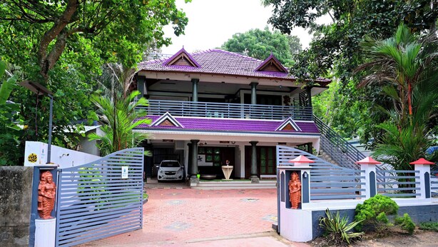 Ein zweigeschossiges Haus mit violettem Dach, einem verschlossenen Eingang und einer Treppe, die zu der oberen Etage führt.