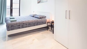 A modern bedroom with a bed, bedside table, and wardrobe. - 2-bedroom apartment in Central Antwerp (Antwerp Center)