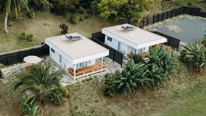 Two modern houses with flat roofs, a wooden deck, and a fenced yard. - Modern Style Villas 5 Min Walk to the Best beach on the Island
Unlimited WIFI In (Rarotonga)