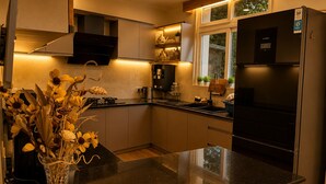 A modern kitchen with a black refrigerator, a sink, and a vase with flowers on the counter.