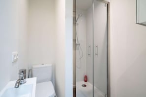 A bathroom with a white sink, toilet, and glass-enclosed shower. - Romantic apartment in Antwerp Centre (Antwerp)