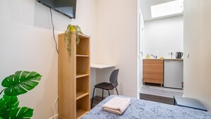 A room with a bed, a desk, a chair, a wardrobe, a television, and a kitchenette. - Romantic apartment in Antwerp Centre (Antwerp)