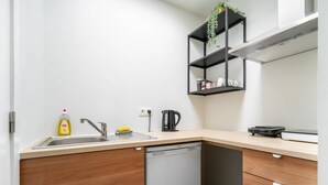 A compact kitchen with a dishwasher, a coffee maker, and a shelf with a plant. - Romantic apartment in Antwerp Centre (Antwerp)