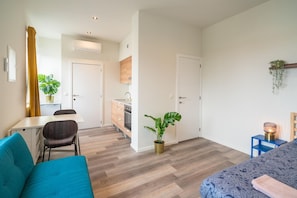 A modern apartment with a dining area, kitchenette, and a living room with a sofa and a bed. - Cosy apartment in Antwerp Centre (Antwerp)