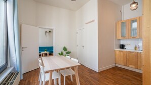 Een moderne keuken met houten kastjes en een eethoek met een tafel en stoelen.