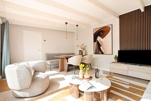 A modern living room with a sofa, coffee table, and a flat-screen TV.