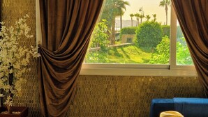 A room with a window, curtains, a sofa, and a hat on the windowsill. - Le Vintage · Tanger Corniche - Sea view, private parking & terrace (Tangier)