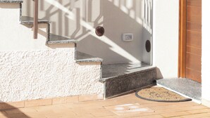A staircase with a metal railing, a wooden door, and a window with a wooden frame. - Hillside village just minutes from the sea, ideal for escaping the daily hustle and bustle (San Floro)
