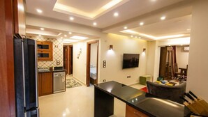Eine moderne Küche mit Kühlschrank, Geschirrspüler und einem Essbereich mit Tisch und Stühlen.
